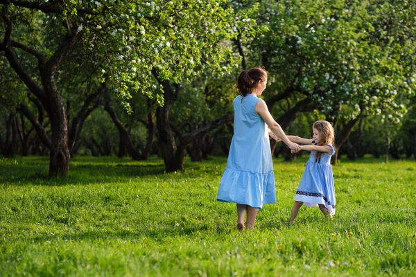 Φύση σκηνή με οικογενειακή εξωτερική τρόπο ζωής. Μητέρα και μικρή κόρη παίζουν μαζί σε ένα πάρκο. Χαρούμενη οικογενειακή ιδέα. Ευτυχία και αρμονία στην οικογενειακή ζωή. — Φωτογραφία Αρχείου