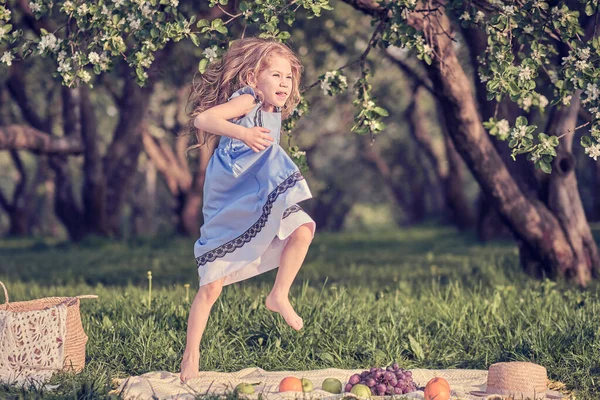 Gelukkige kleine meid die plezier heeft in het park. Leuk kind zittend op het gras op een zonnige zomerdag. — Stockfoto