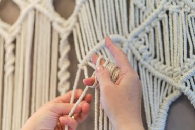 El yapımı makrome doku deseni yakın plan. ECO dostu modern örgü doğal dekorasyon konsepti. Güzel boho makrome duvar paneli rahat bir atmosfer ekler.