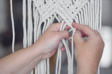 El yapımı makrome doku deseni yakın plan. ECO dostu modern örgü doğal dekorasyon konsepti. Güzel boho makrome duvar paneli rahat bir atmosfer ekler.