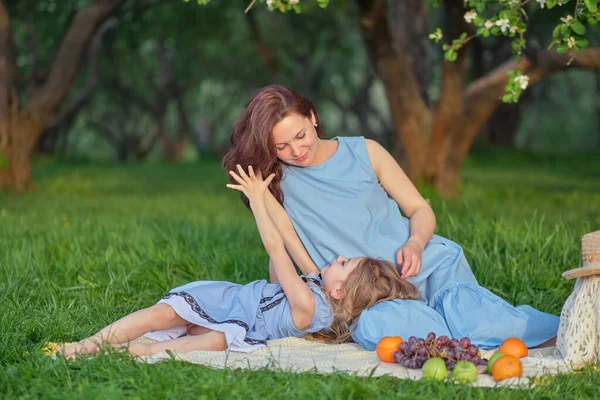 Moeder en kind hebben plezier in het park. Moeder en dochtertje spelen samen in een park. Gelukkig familieconcept. — Stockfoto