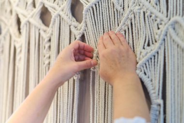 El yapımı makrome doku deseni yakın plan. ECO dostu modern örgü doğal dekorasyon konsepti. Güzel boho makrome duvar paneli rahat bir atmosfer ekler.