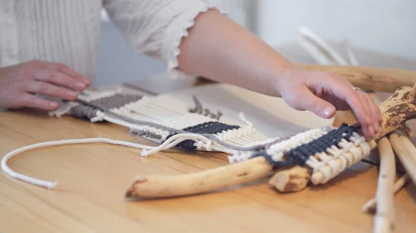 Frau arbeitet an benutzerdefinierten Makramdekor mit Werkzeugen über einem kreativen Desktop beobachtet von oben. Hobby Strickmakram aus Hand und Faden. — Stockfoto