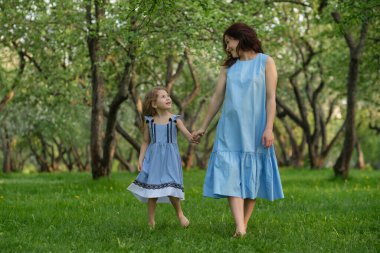 Anne ve çocuk parkta eğleniyorlar. Anne ve küçük kızı parkta birlikte oynuyorlar. Mutlu aile kavramı.