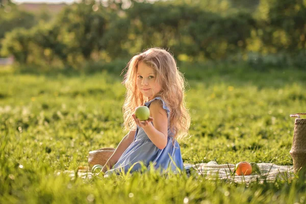 Menina feliz se divertindo no parque. Criança bonito sentado na grama em um dia ensolarado de verão — Fotografia de Stock