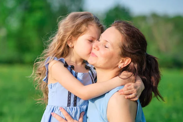 Naturszene mit familiärem Outdoor-Lifestyle. Mutter und kleine Tochter spielen zusammen in einem Park. Glückliches Familienkonzept. Glück und Harmonie im Familienleben. — Stockfoto