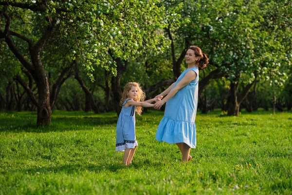 Scène de nature avec style de vie familial en plein air. Mère et petite fille jouent ensemble dans un parc. Joyeux concept de famille. Bonheur et harmonie dans la vie familiale. — Photo