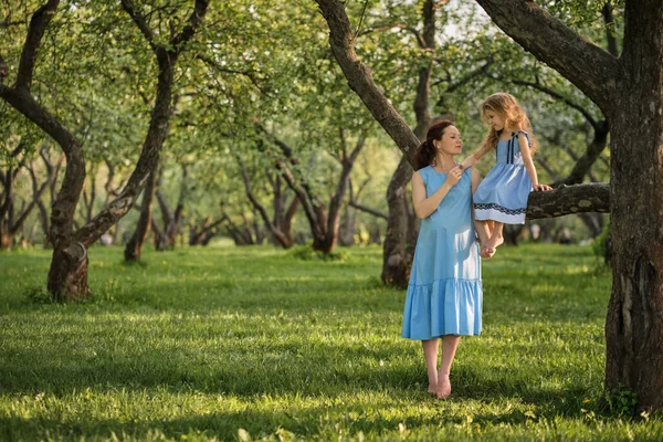 Moeder en kind hebben plezier in het park. Moeder en dochtertje spelen samen in een park. Gelukkig familieconcept. — Stockfoto