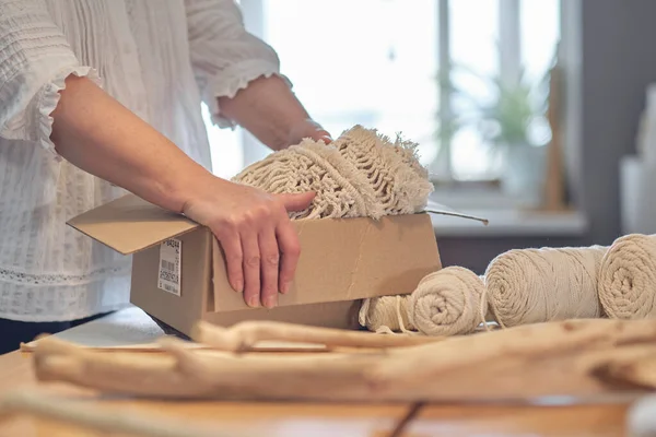 Femme entrepreneur emballe un produit fait à la main dans une boîte en carton. livraison de marchandises pour une petite entreprise. une femme âgée gagne son passe-temps de la maison. — Photo