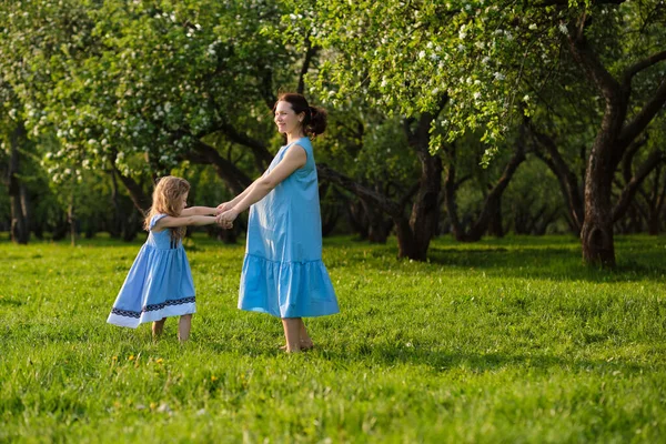 Cena da natureza com estilo de vida familiar ao ar livre. Mãe e filha brincando juntas em um parque. Feliz conceito de família. Felicidade e harmonia na vida familiar. — Fotografia de Stock