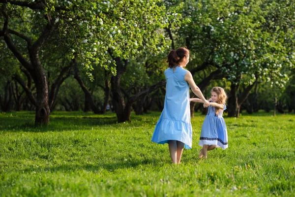 Cena da natureza com estilo de vida familiar ao ar livre. Mãe e filha brincando juntas em um parque. Feliz conceito de família. Felicidade e harmonia na vida familiar. — Fotografia de Stock