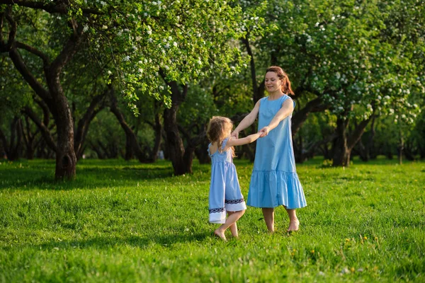 Cena da natureza com estilo de vida familiar ao ar livre. Mãe e filha brincando juntas em um parque. Feliz conceito de família. Felicidade e harmonia na vida familiar. — Fotografia de Stock