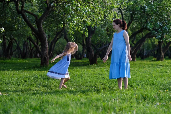 Cena da natureza com estilo de vida familiar ao ar livre. Mãe e filha brincando juntas em um parque. Feliz conceito de família. Felicidade e harmonia na vida familiar. — Fotografia de Stock