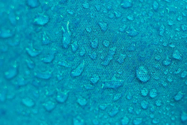 Vatten Proof Textil blockera vatten för att passera igenom för att hålla sig torr. vattenpärlor på tyg. mjuk fokusering, suddig — Stockfoto