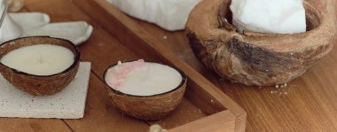 Hindistan cevizi spa konsepti: Hindistan cevizi yağı, hindistan cevizi yağı ve ahşap bir masada hindistan cevizi kokusu olan mum. aromaterapi kavramı