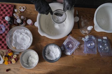 El yapımı banyo bombaları. Banyo bombaları hazırlanıyor. İçindekiler ve çiçek dekoru ahşap bir şarap masasında..