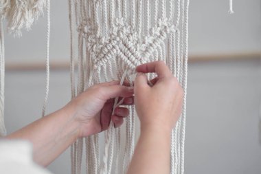 El yapımı makrome doku deseni yakın plan. ECO dostu modern örgü doğal dekorasyon konsepti. Güzel boho makrome duvar paneli rahat bir atmosfer ekler.