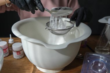 El yapımı banyo bombaları. Banyo bombaları hazırlanıyor. İçindekiler ve çiçek dekoru ahşap bir şarap masasında..