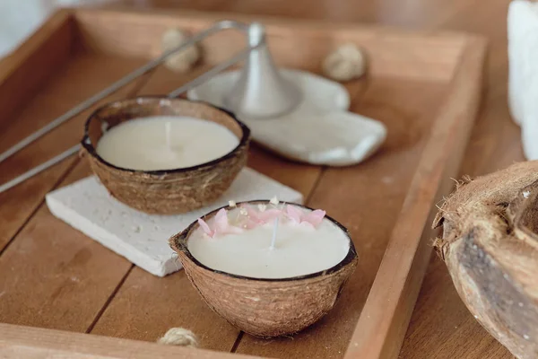 Kókuszfürdő koncepció: kókusz, kókuszolaj és gyertya kókuszillattal egy fából készült asztalon. aromaterápiás koncepció — Stock Fotó