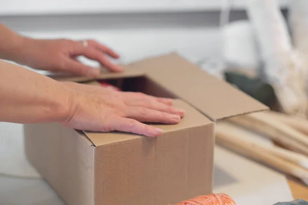 Femme entrepreneur emballe un produit fait à la main dans une boîte en carton. livraison de marchandises pour une petite entreprise. une femme âgée gagne son passe-temps de la maison. — Photo