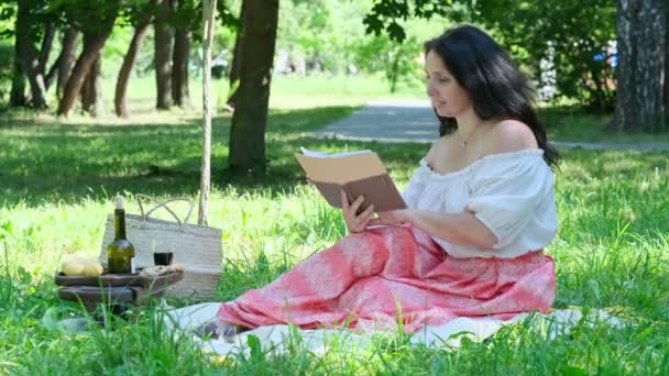 밖에 혼자 앉아 있는 사려깊은 여자. 노부인 이 공원에서 여름날을 즐기는 모습. — 비디오