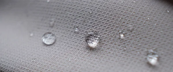 Wasserperlen auf Stoff. Wasserdichte Beschichtung Hintergrund mit Wassertropfen. Weicher Fokus, Unschärfe — Stockfoto