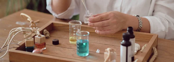 Close-up of a pipette with oil and a glass bottle. woman pouring perfume in bottle. Perfume creating workshop — Stock Photo, Image