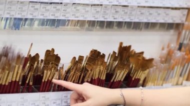 Sanat atölyesinde çizim için fırça seçen kadın.