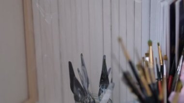 Sanatçı atölyesinin ayrıntıları, baskınlar, fırçalar, çözülmeler. Sanat stüdyosu boya fırçaları ve mürekkep resimleri.