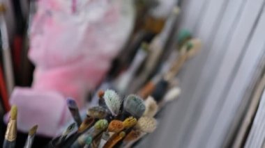 Sanatçı atölyesinin ayrıntıları, baskınlar, fırçalar, çözülmeler. Sanat stüdyosu boya fırçaları ve mürekkep resimleri.
