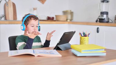 Akıllı çocuk tablet hakkında online ders dinliyor kulaklık takıyor Spbas. Evde eğitim görmüş çocuk gözetimi.