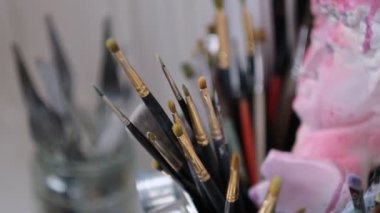 Sanatçı atölyesinin ayrıntıları, baskınlar, fırçalar, çözülmeler. Sanat stüdyosu boya fırçaları ve mürekkep resimleri.