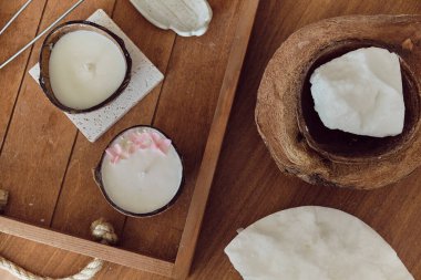 Hindistan cevizi spa konsepti: Hindistan cevizi yağı, hindistan cevizi yağı ve ahşap bir masada hindistan cevizi kokusu olan mum. aromaterapi kavramı