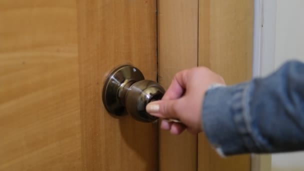O femeie care foloseşte o cheie pentru a deschide încuietoarea uşii din faţă. femeie se întoarce acasă, o fată intră în cameră — Videoclip de stoc