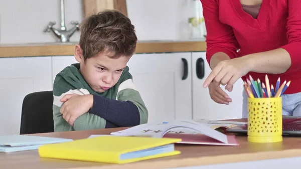 Öfkeli, ciddi bir anne, tembel, motivasyonsuz okul çocuğuna, çocukların eğitim sorununa, ebeveynlerin ve çocukların anlaşmazlığına ders veriyor. Stresli anne ve oğlu ödevlerini yapamadığı için hayal kırıklığına uğramış.. — Stok fotoğraf