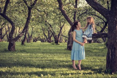 Anne ve çocuk parkta eğleniyorlar. Anne ve küçük kızı parkta birlikte oynuyorlar. Mutlu aile kavramı.