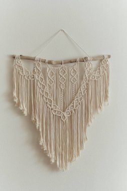Duvar panelinde güzel bir makrome. Ev dekorasyonu ve düğün dekorasyonu için makrome tekniğini kullanarak doğal renklerde pamuk ipliklerden yapılmış Boho tarzı goblen. açık renkli renkler