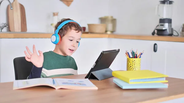 Okos fiú diák hallgatni online leckét tabletta visel fejhallgató Spbas. Magániskolás gyermekfelügyelet. — Stock Fotó