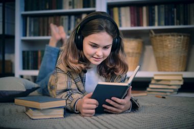 Genç kız yatak odasındaki bir masada ödev yapıyor. Genç kız öğrenci notlar yazıyor internetten video izleyip bilgisayardan öğreniyor. Uzaktan öğrenme kursu video konferansı pc çağrısı.