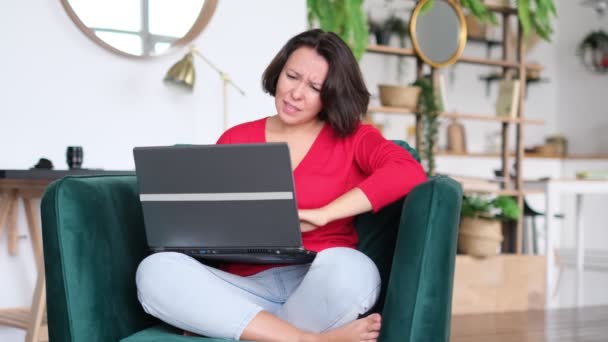 Egy szomorú nő dolgozik a laptopján. Boldogtalan ember számítógépes technológiát használ otthon. Aggódó lány stressz szabadúszó munka otthon munkahelyi — Stock videók