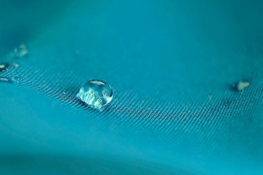 Kumaşta boncuk boncuk su. Su damlaları ile su geçirmez kaplama arka planı