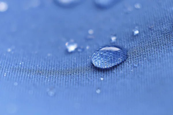 Abalorios de agua en la tela. Fondo de recubrimiento impermeable con gotas de agua —  Fotos de Stock