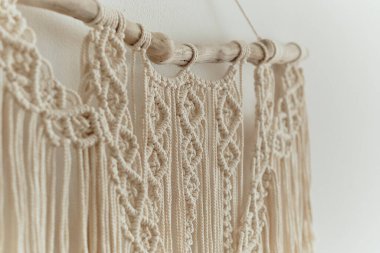 Duvar panelinde güzel bir makrome. Ev dekorasyonu ve düğün dekorasyonu için makrome tekniğini kullanarak doğal renklerde pamuk ipliklerden yapılmış Boho tarzı goblen. açık renkli renkler