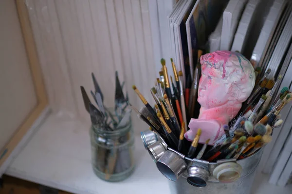 Detalhes da oficina de artistas, busto e escovas, desfoque. Pincéis de pintura de estúdio de arte e pinturas de tinta. desfocagem — Fotografia de Stock