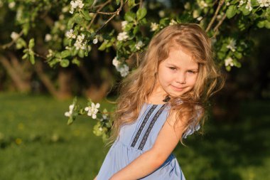 Küçük mutlu kızın portresi kiraz ağacı çiçekleri. bahar çiçekleri