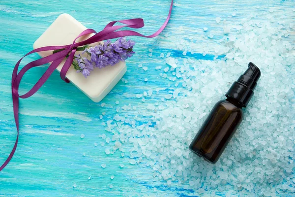 Silice láhve přírodní organické mýdlo a mořská sůl na modrý dřevěný stůl, lázně — Stock fotografie