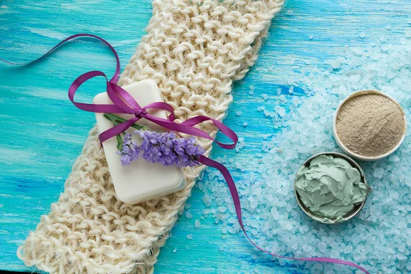 Natuurlijke biologische zeep en zee zout kruidenbad op een blauwe houten tafel, met bloemen — Stockfoto