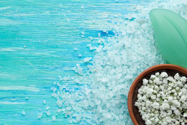 Натуральное органическое мыло и морская соль с цветами на голубом деревянном столе — стоковое фото