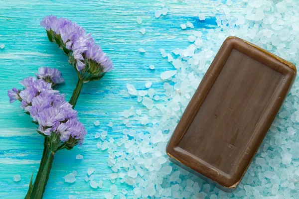 Natuurlijke biologische zeep, en zeezout met bloemen op een blauwe houten tafel — Stockfoto