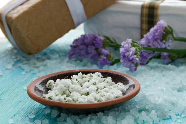 Zeezout op een blauwe houten tafel, met bloemen — Stockfoto